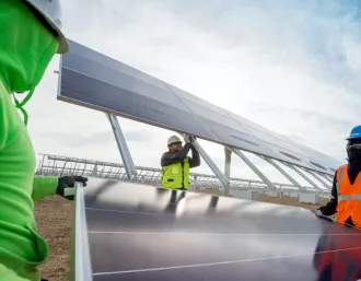 solar panel installers carrying a solar panel