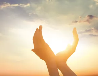 two hands appear to hold the sun