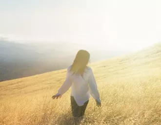 Woman walking in sunny field