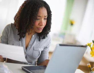 woman at laptop reviewing a utility bill