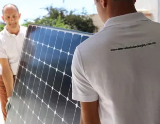 Installers carrying solar panel