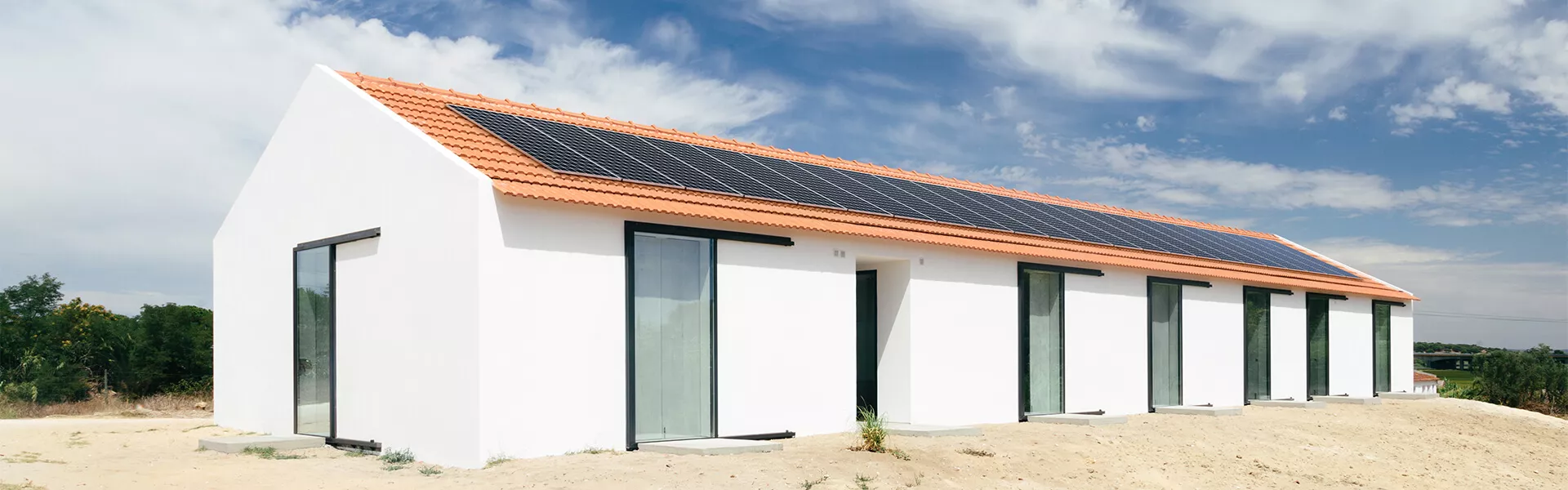 casa con cielo azul y nubes con paneles solares