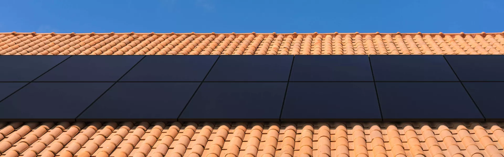  casa con tejas rojas y paneles solares